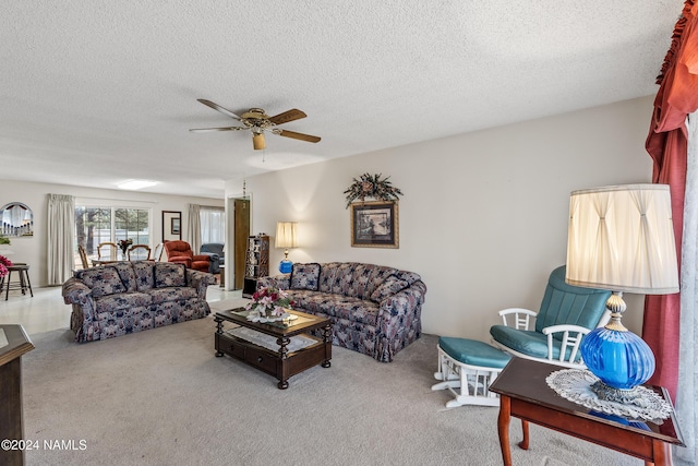 living room with ceiling fan, a textured ceiling, and carpet