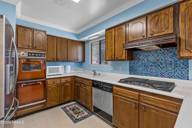 kitchen featuring sink, stainless steel appliances, ornamental molding, and tasteful backsplash