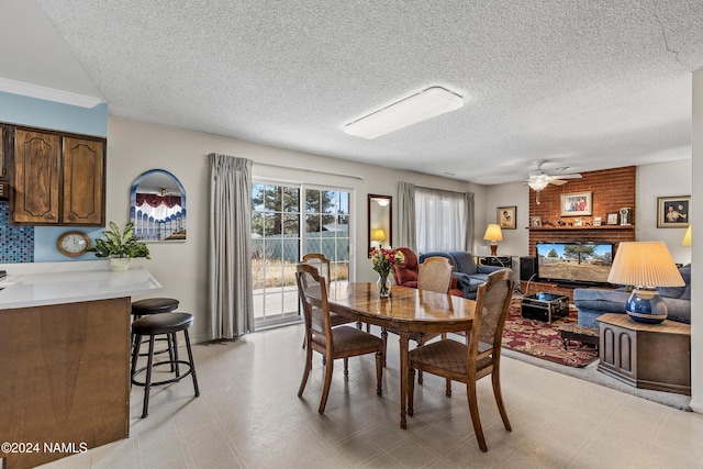 dining area with ceiling fan and a textured ceiling