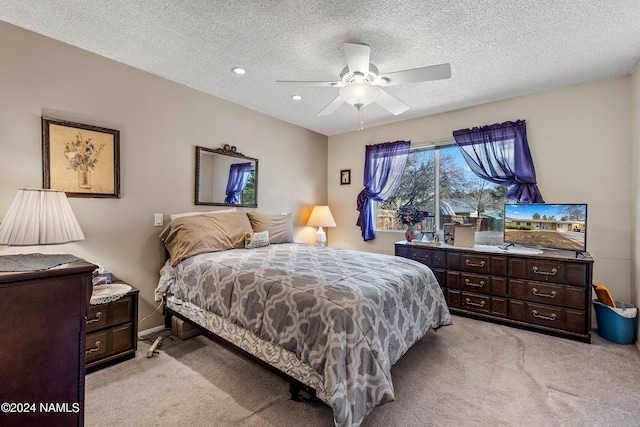 bedroom with light colored carpet, a textured ceiling, and ceiling fan