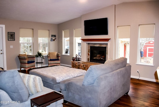living room featuring lofted ceiling, baseboards, a fireplace, and dark wood-type flooring