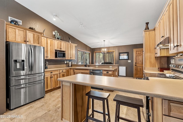 kitchen featuring under cabinet range hood, stainless steel appliances, a peninsula, a kitchen breakfast bar, and decorative light fixtures