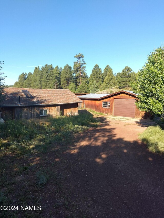 1600 S River Valley Rd, Flagstaff, AZ 86004 - view of side of property featuring dirt driveway, an outdoor structure, and a garage