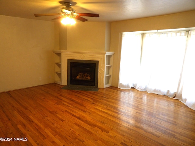 unfurnished living room featuring ceiling fan and wood-type flooring