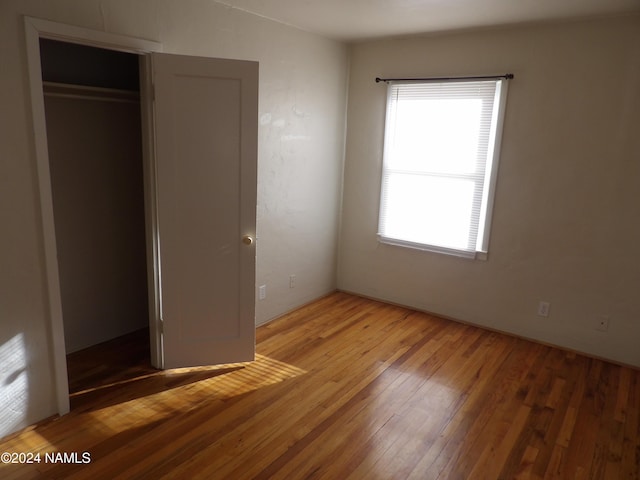 unfurnished bedroom with a closet and hardwood / wood-style floors