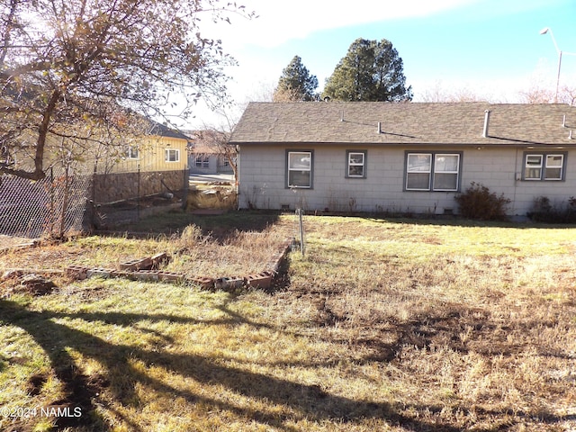 rear view of property with a lawn