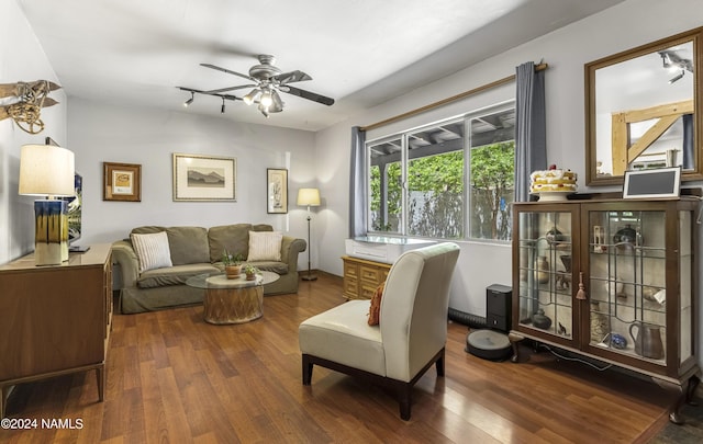 living room with ceiling fan and dark hardwood / wood-style flooring