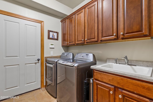 laundry room featuring cabinets, sink, light tile patterned floors, and independent washer and dryer