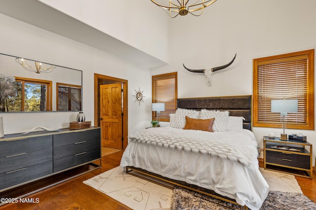 bedroom with dark hardwood / wood-style floors and a chandelier