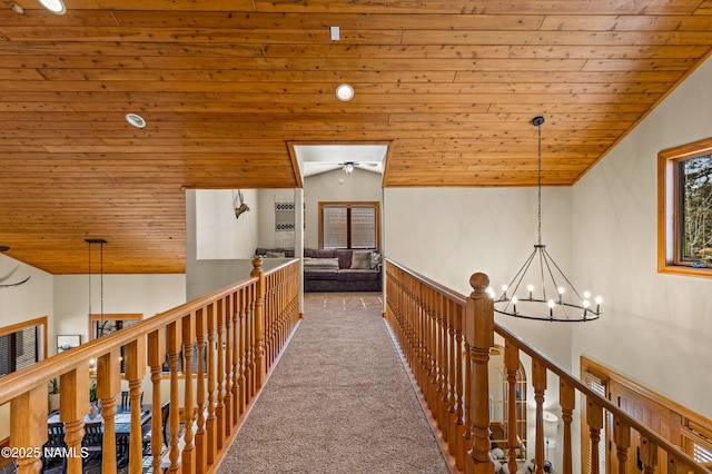 hall featuring lofted ceiling, carpet floors, a notable chandelier, and wood ceiling