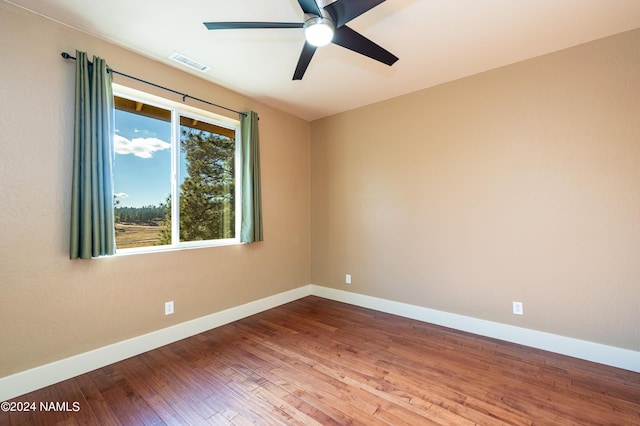 unfurnished room featuring ceiling fan, a wealth of natural light, and hardwood / wood-style floors