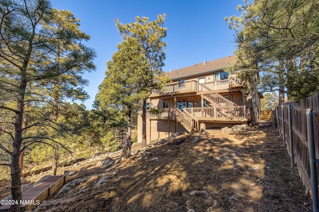 rear view of house featuring a wooden deck