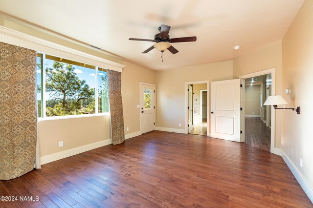 unfurnished room with ceiling fan and dark wood-type flooring