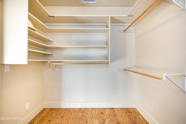 walk in closet with hardwood / wood-style flooring