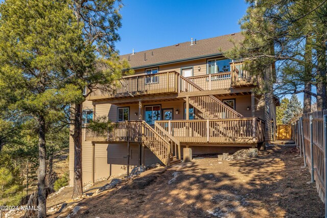 rear view of property with a deck and a garage