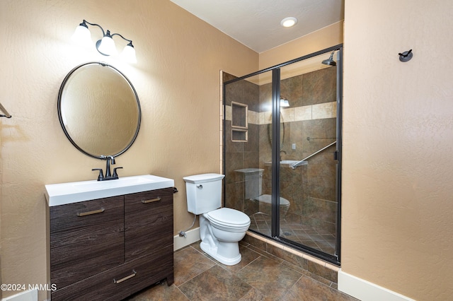 bathroom featuring toilet, an enclosed shower, and vanity