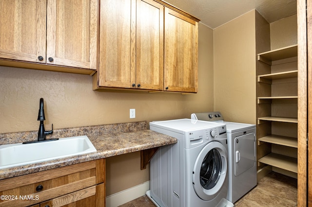 washroom featuring sink, cabinets, and washer and dryer