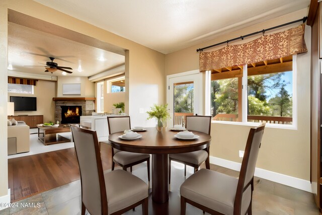 dining area featuring a fireplace and ceiling fan