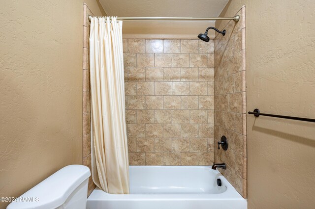 bathroom with toilet and shower / tub combo with curtain