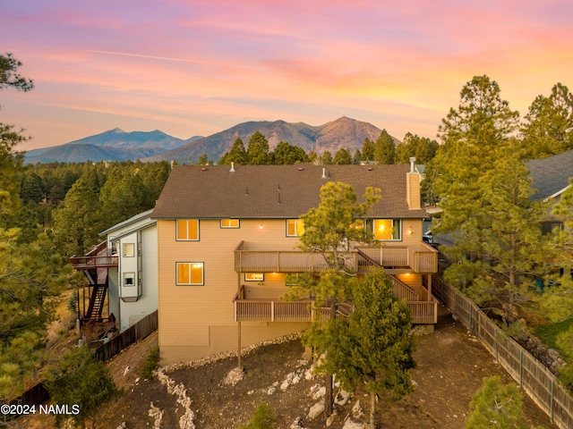 back house at dusk featuring a balcony and a deck with mountain view