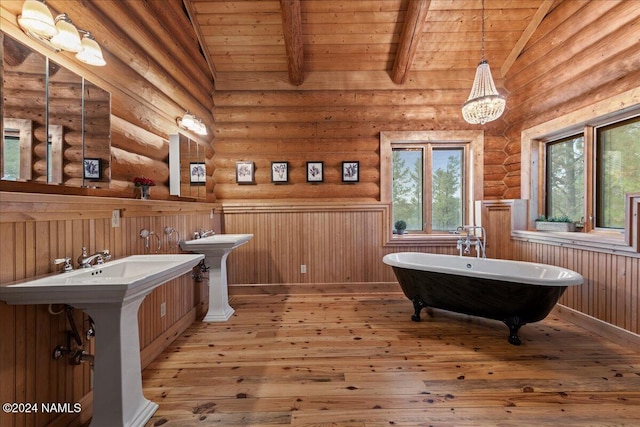 bathroom featuring double sink, rustic walls, vaulted ceiling with beams, and wooden ceiling