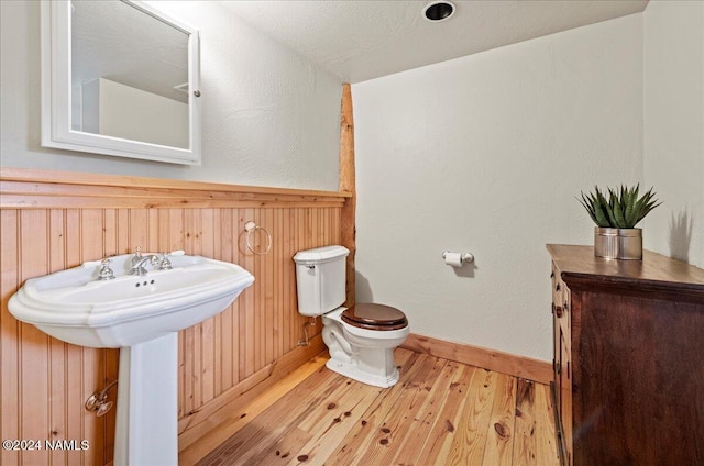 bathroom featuring sink, toilet, hardwood / wood-style floors, and a textured ceiling