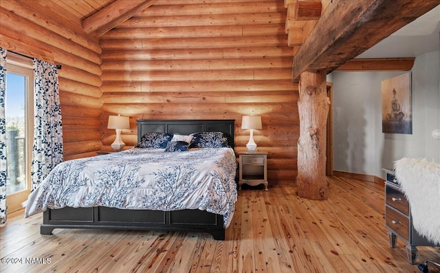 bedroom with rustic walls, beamed ceiling, and light hardwood / wood-style flooring