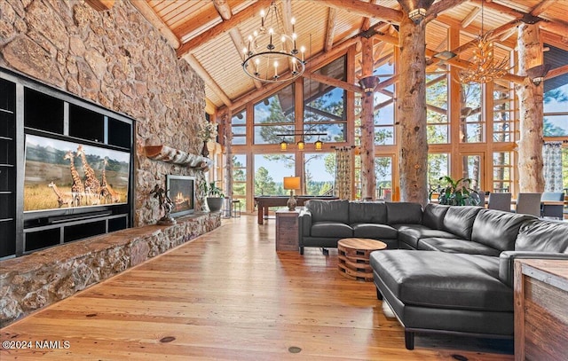 living room with a wealth of natural light, beamed ceiling, hardwood / wood-style flooring, a chandelier, and high vaulted ceiling