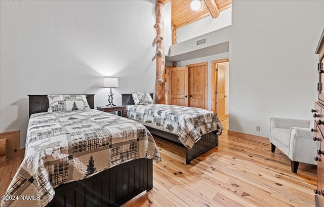 bedroom featuring high vaulted ceiling, wooden ceiling, light hardwood / wood-style flooring, and beam ceiling