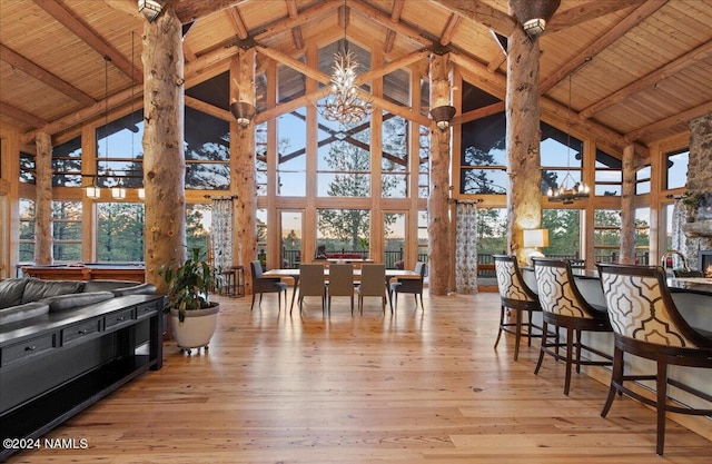 sunroom / solarium featuring an inviting chandelier, vaulted ceiling with beams, and wooden ceiling