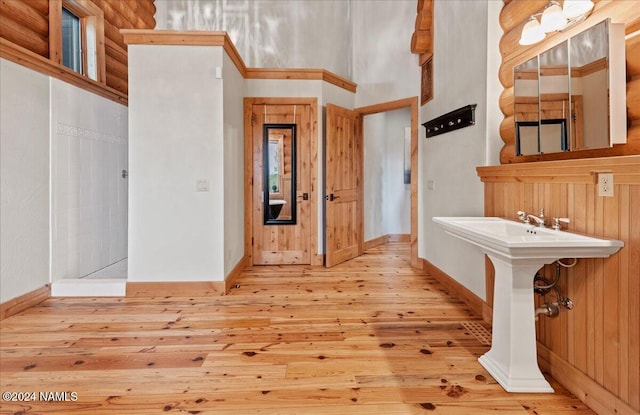 bathroom featuring wood-type flooring and rustic walls