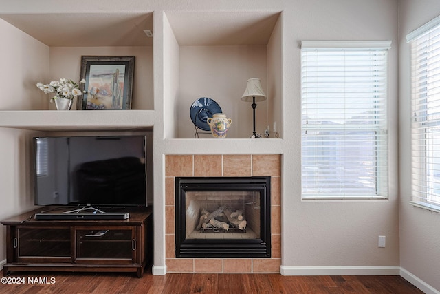 interior details with hardwood / wood-style floors and a tiled fireplace