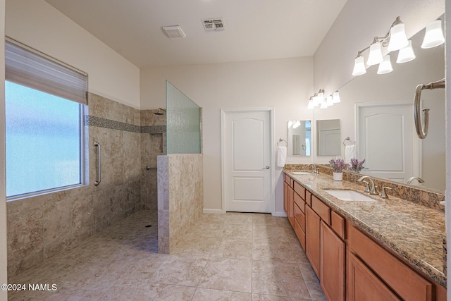 bathroom featuring vanity, tiled shower, and tile patterned flooring