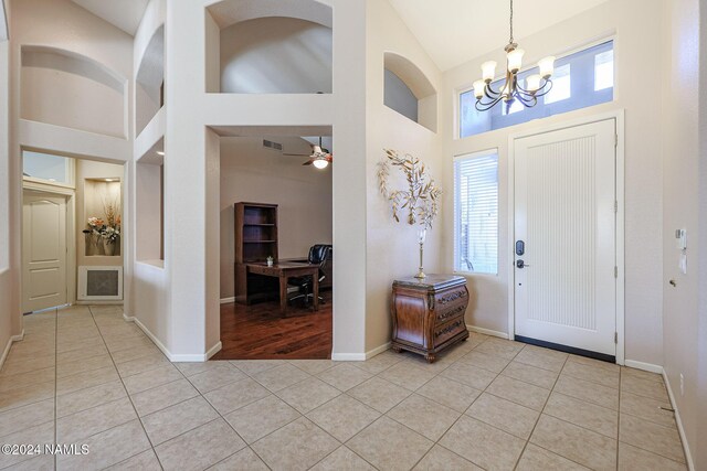 tiled entrance foyer with a high ceiling and an inviting chandelier