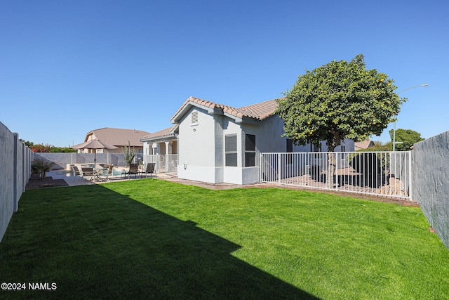 back of property with a lawn and a patio