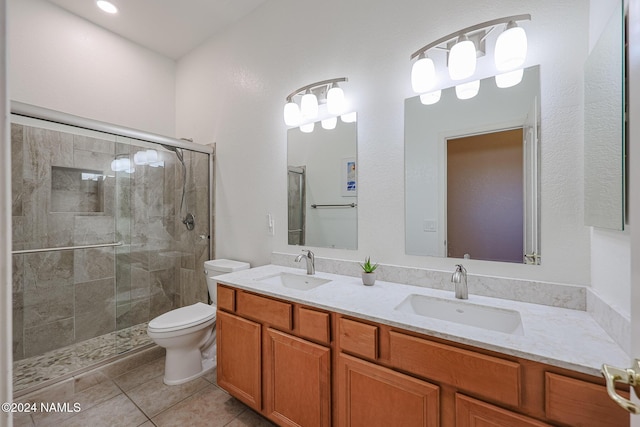 bathroom with toilet, a shower with shower door, tile patterned floors, and vanity