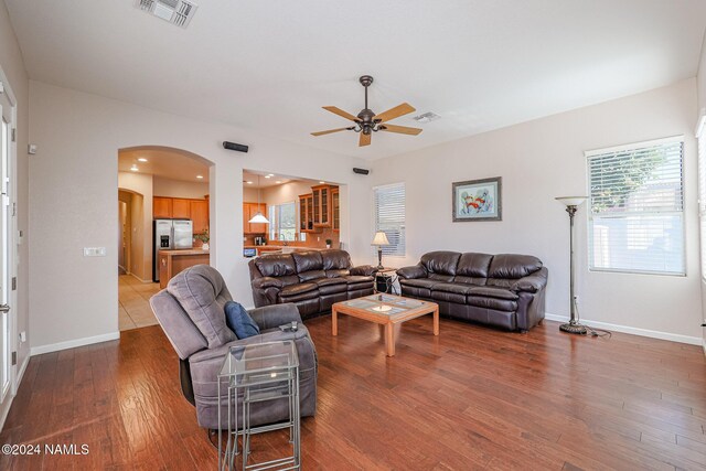 living room with wood-type flooring and ceiling fan