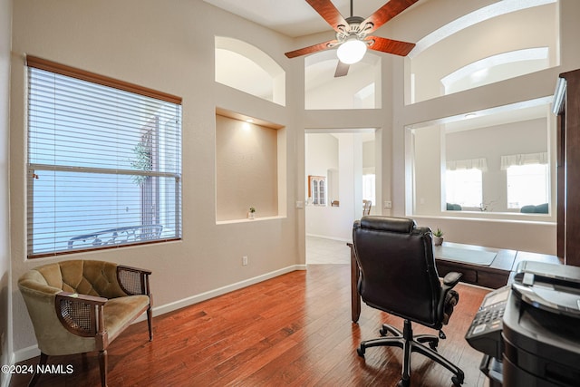 office space with high vaulted ceiling, hardwood / wood-style flooring, and ceiling fan