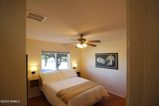 bedroom with ceiling fan and dark hardwood / wood-style floors