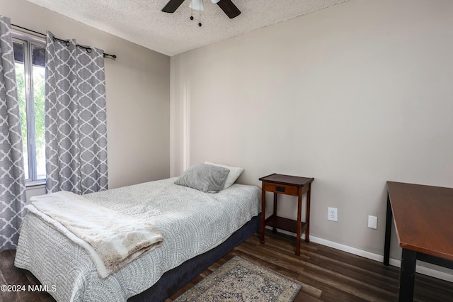 bedroom featuring ceiling fan, dark wood-type flooring, and a textured ceiling