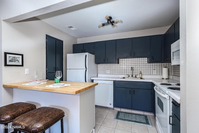 kitchen featuring white appliances, wooden counters, a kitchen bar, sink, and blue cabinets