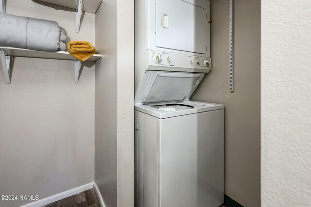 laundry area featuring stacked washer / dryer and hardwood / wood-style floors