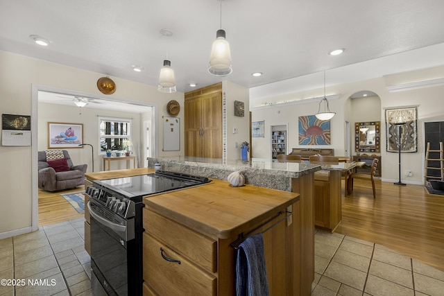 kitchen featuring brown cabinets, a kitchen island, and electric stove