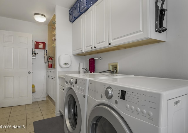 laundry room featuring washer and clothes dryer, cabinet space, and light tile patterned flooring