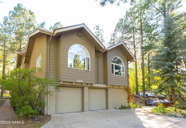 3115 Tina Ln, Flagstaff, AZ 86001 - view of front of property featuring concrete driveway, a garage, and brick siding