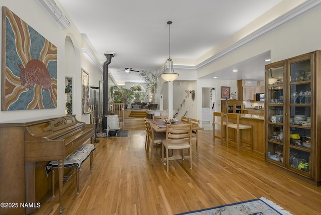 dining area featuring crown molding and light wood-style floors