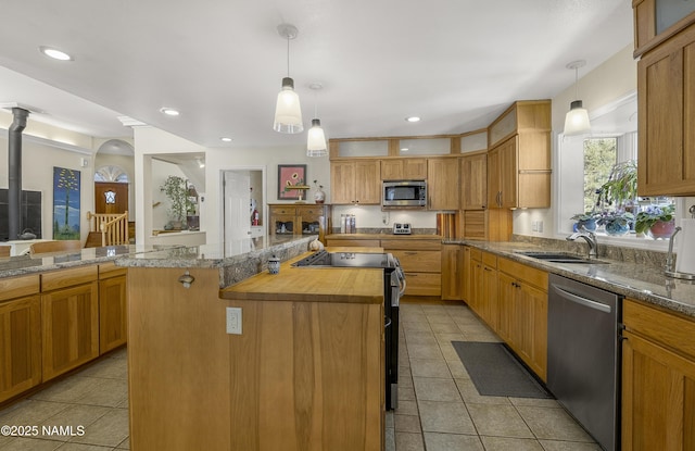 kitchen featuring a sink, a center island, recessed lighting, appliances with stainless steel finishes, and light tile patterned flooring