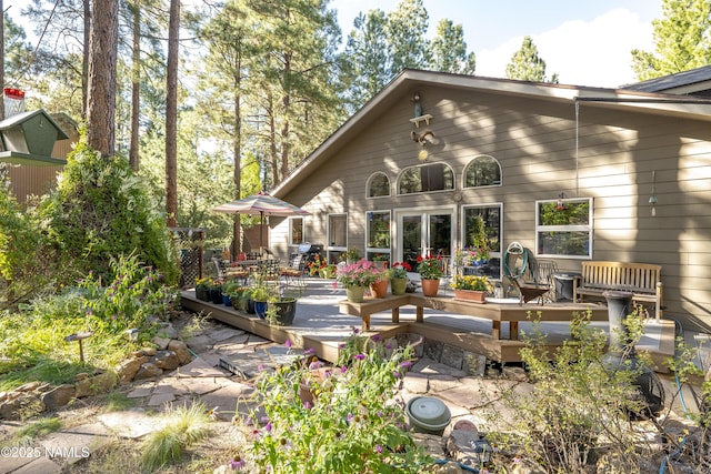 rear view of property with french doors and a wooden deck