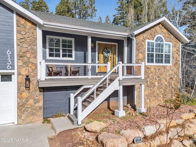 6136 E Abineau Canyon Dr, Flagstaff, AZ 86004 - view of front of home with stone siding, covered porch, a garage, and stairway