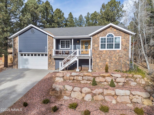 6136 E Abineau Canyon Dr, Flagstaff, AZ 86004 - single story home featuring stone siding, a porch, driveway, stairway, and a garage